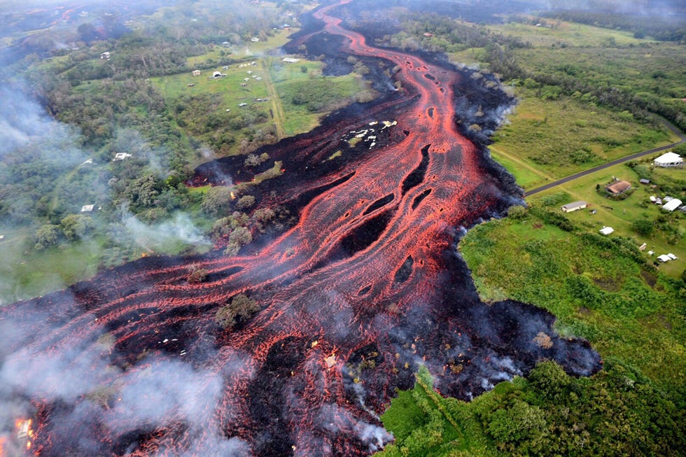 Aswolken hangen boven de jungle tijdens een zware uitbarsting van de vulkaan Kilauea op het Big Island van Hawa in mei 2018 De Punauitbarsting die lager op de berg plaatsvond duurde de hele maand augustus en produceerde verwoestende lavastromen en fonteinen De lava stroomde over naburige kavels en blokkeerde ook een snelweg