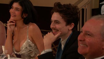 two individuals at a social gathering one wearing a sparkling dress