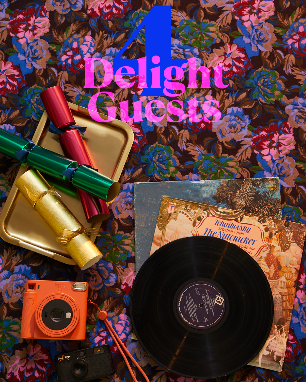 a festive flat lay featuring colorful party crackers a vinyl record and vintage cameras on a floral fabric background