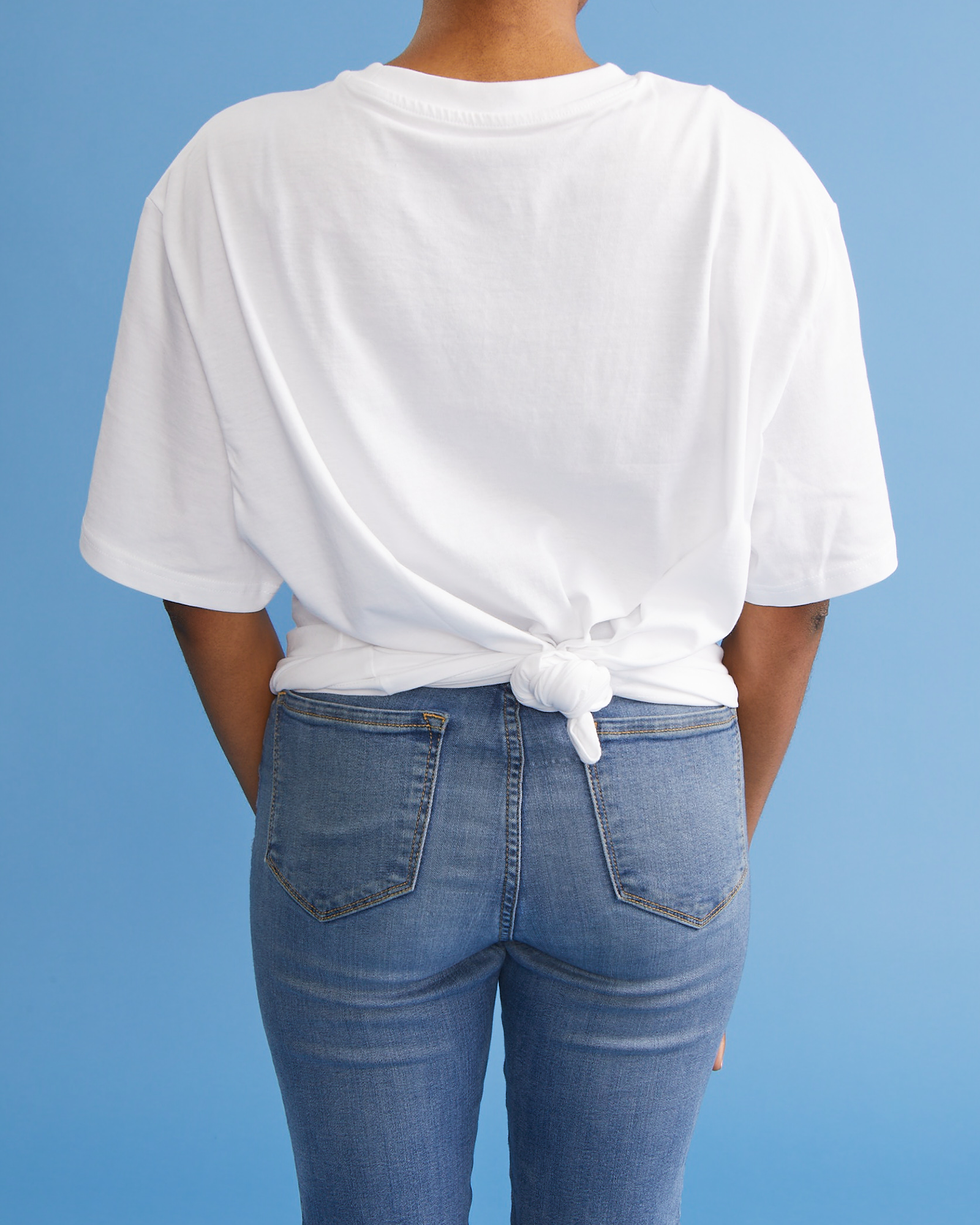 how lớn tie a shirt back knot on a woman's white shirt while she wears jeans