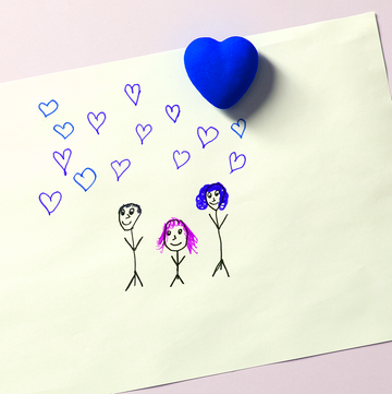 a piece of paper with a drawing of a family of three on it a piece of paper with a drawing of a family of three on it