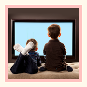 two young boys from behind watching television