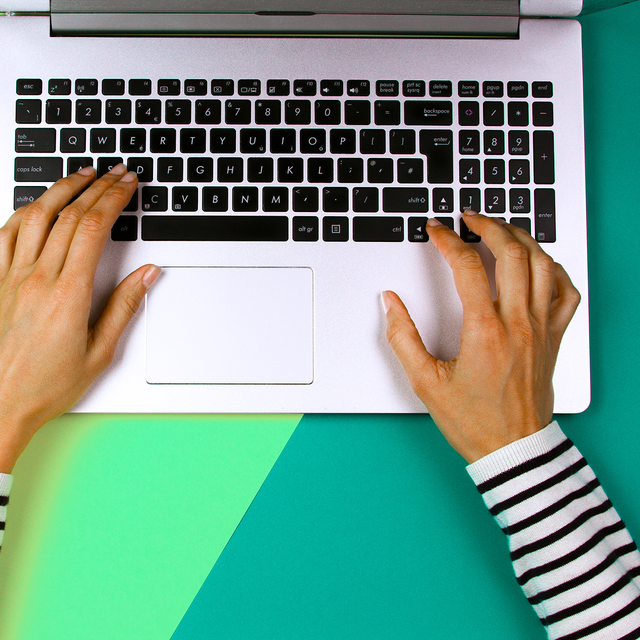 womans hands typing on laptop