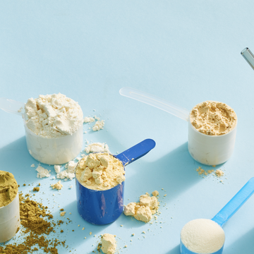 best protein powders selected by good housekeeping on a blue background with scoops of powder