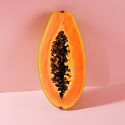a piece of fruit cut in half on a pink background