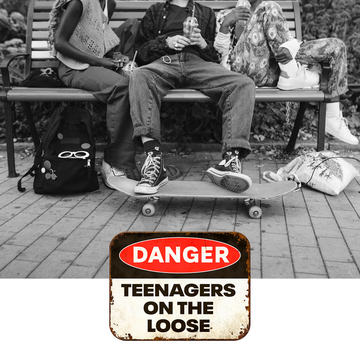 teens sitting on a bench with a skateboard and book bags and sign that says danger teens on the loose teens sitting on a bench with a skateboard and book bags and sign that says danger teens on the loose