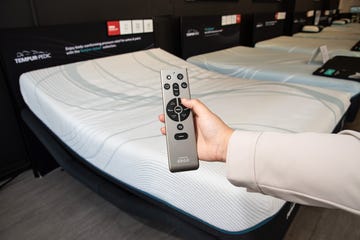 a person holding a remote for an adjustable bed