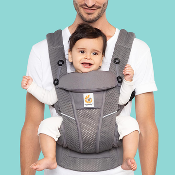 ergobaby carrier review good housekeeping a man holds a baby facing front in an ergobaby carrier