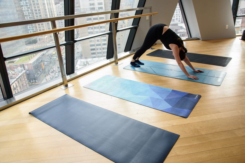 a woman doing a downward dog in a fitness studio