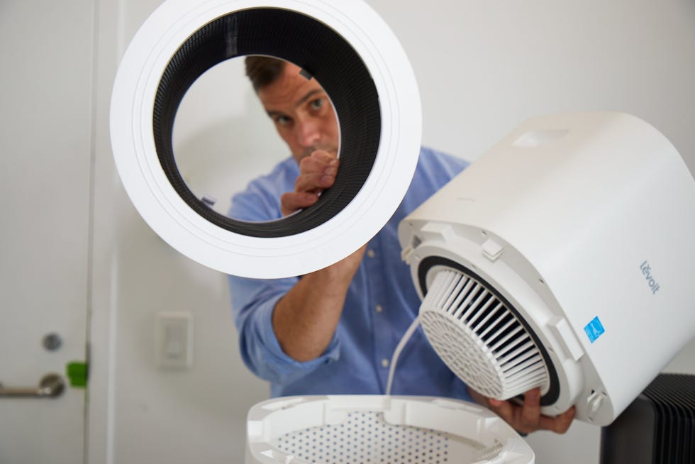an expert examines the filter on an air purifier test