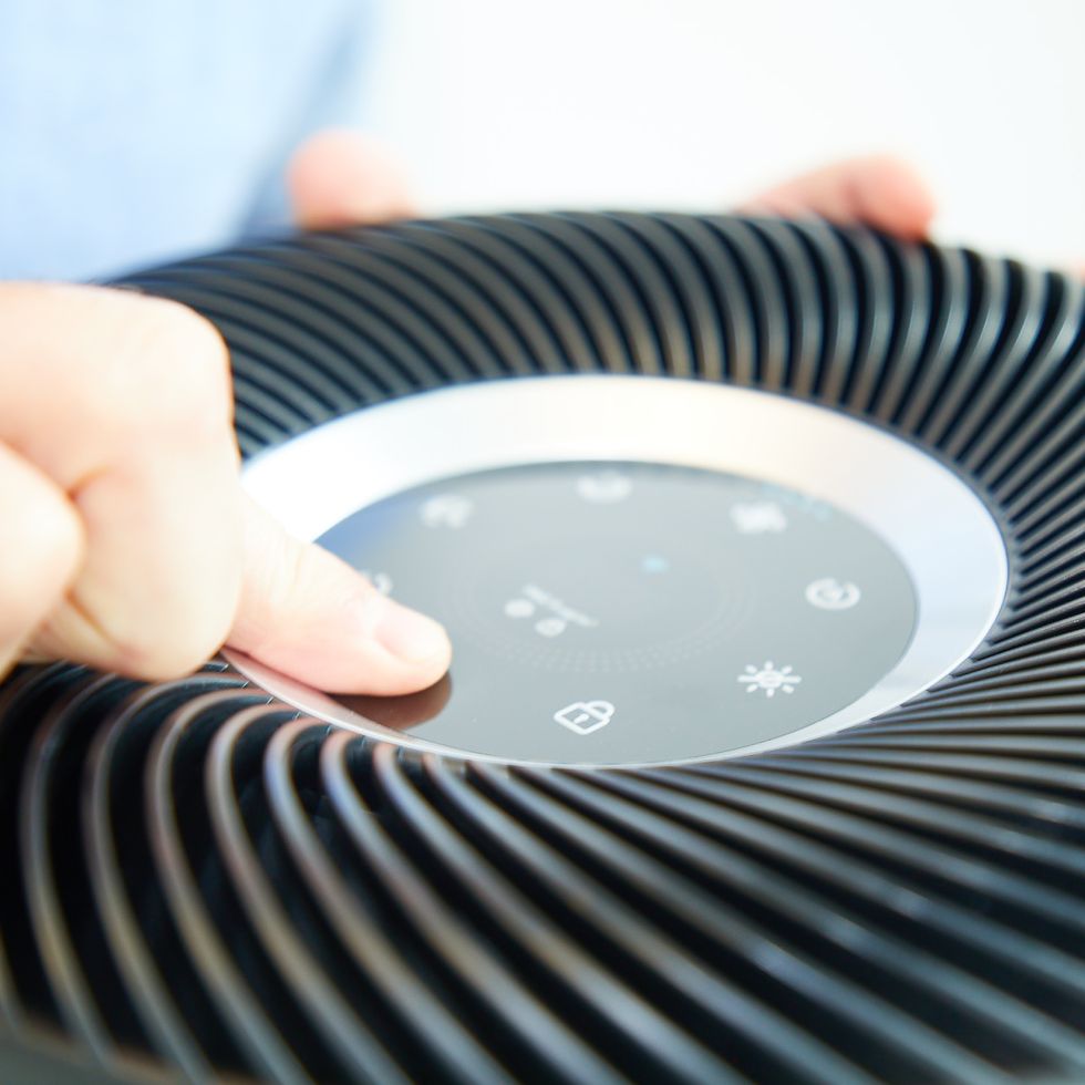 a product tester evaluates the ease of use of an air purifiers digital controls