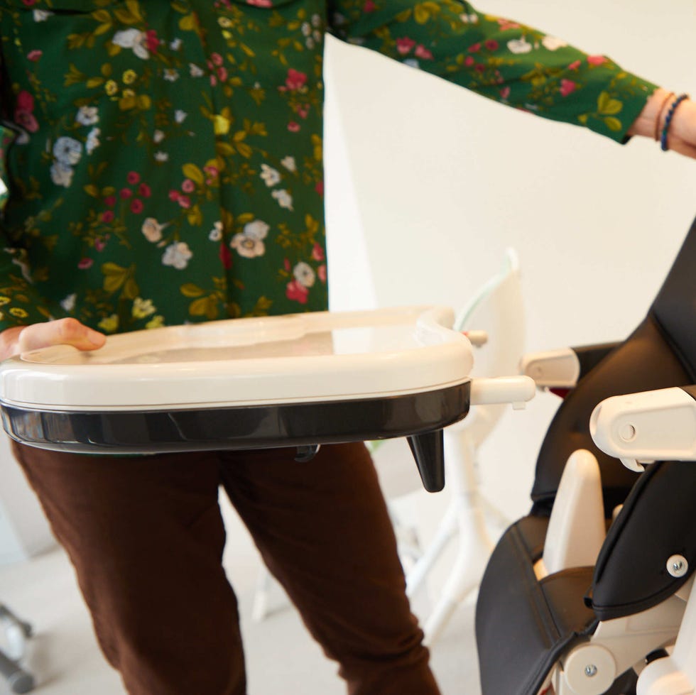 Testing a high chair tray at the Good Housekeeping Institute a member of the good housekeeping institute tests a high chair tray