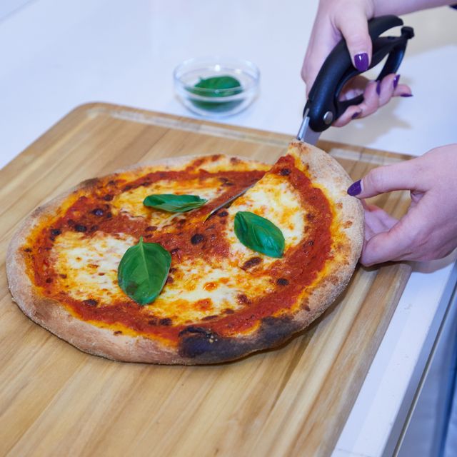 cutting freshly made pizza