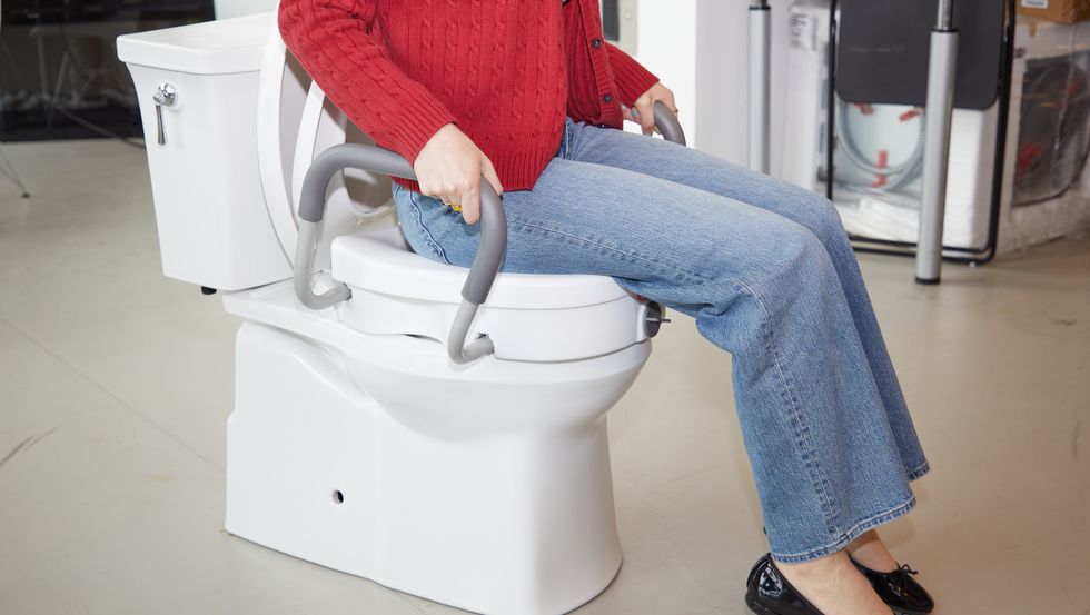 a tester evaluates a toilet seat riser for comfort and stability