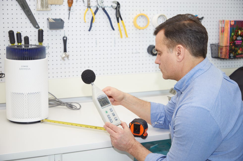 an expert uses a decibel meter to measure noise from an air purifier