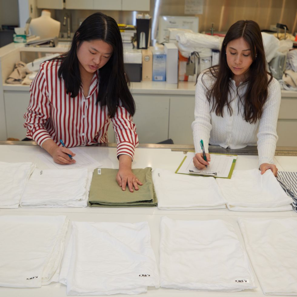 two consumer testers touching and rating softness of sheets