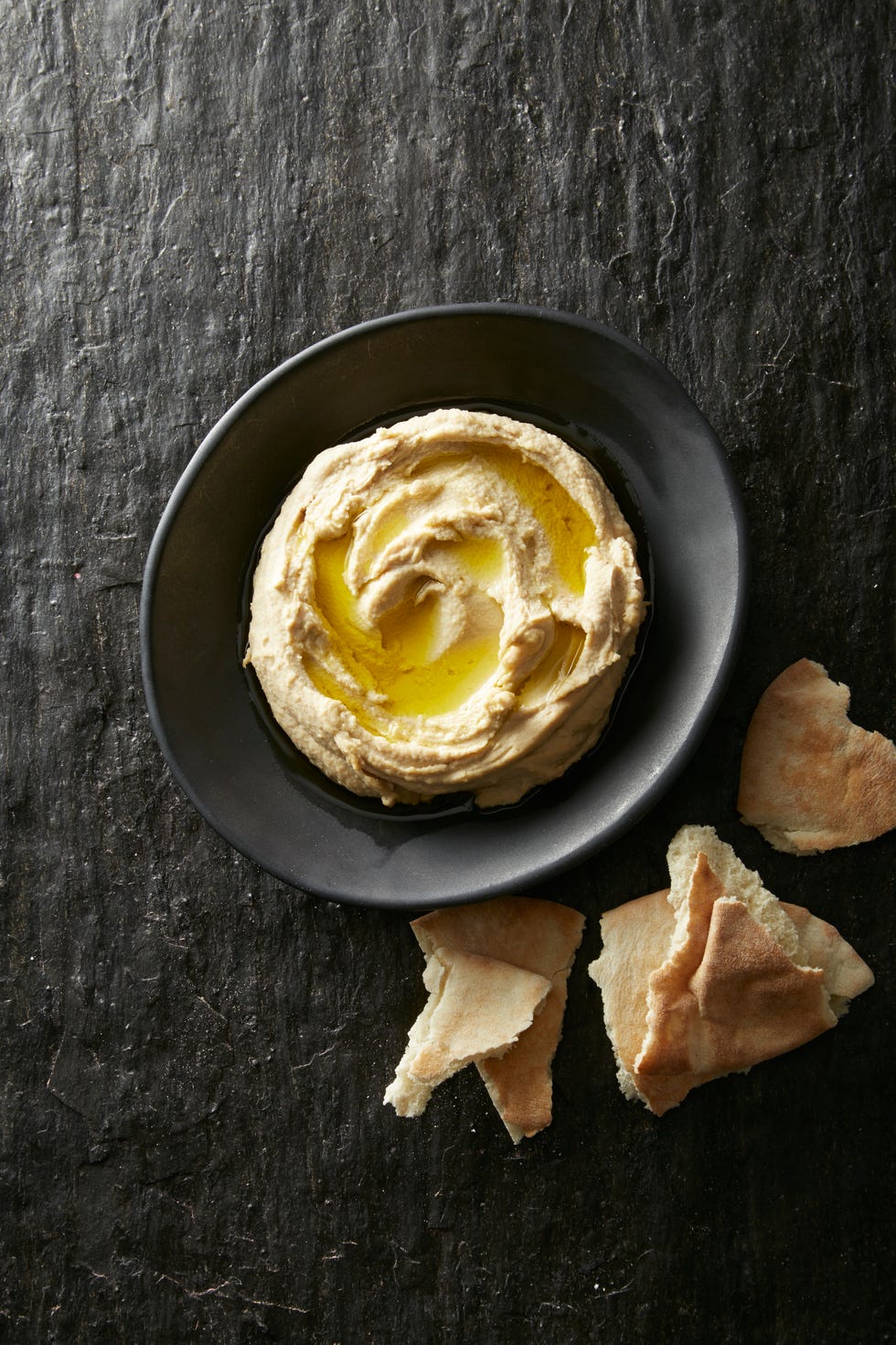 homemade hummus with torn pita on the side