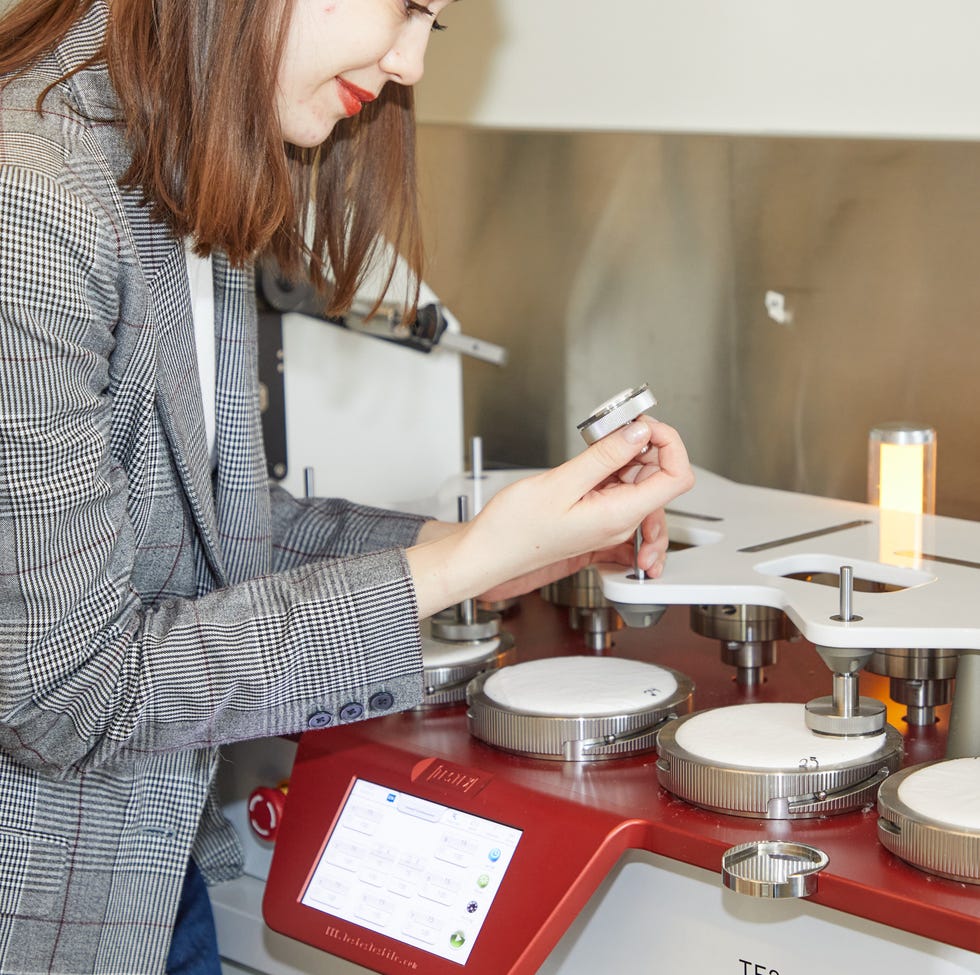 best leggings - testing image a good housekeeping analyst evaluating the abrasion machine as part of our best leggings testing, good housekeeping