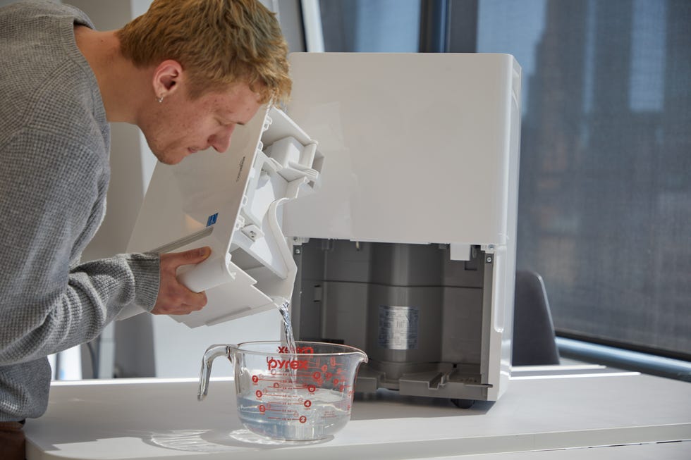 an expert measures how much was water was collected by a dehumidifier