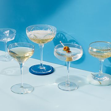 coupe glasses filled with drinks on a blue background