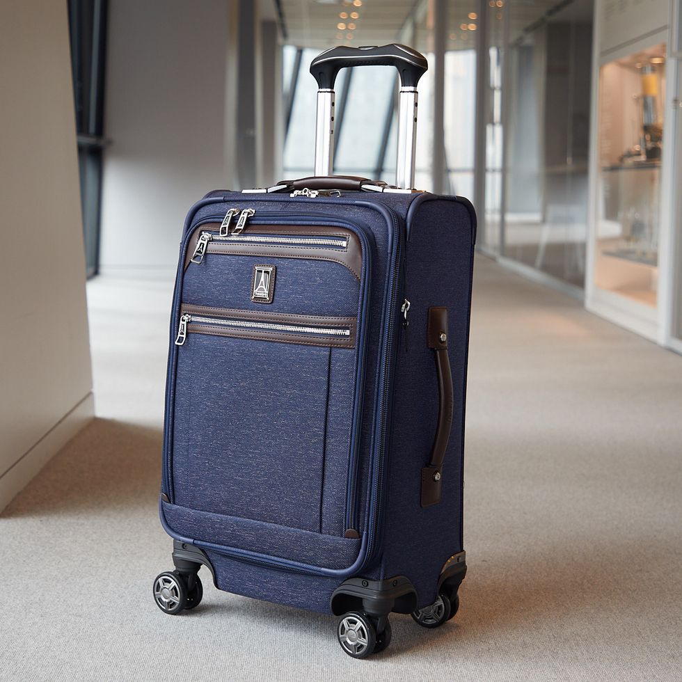 a blue suitcase from travelpro in a hallway