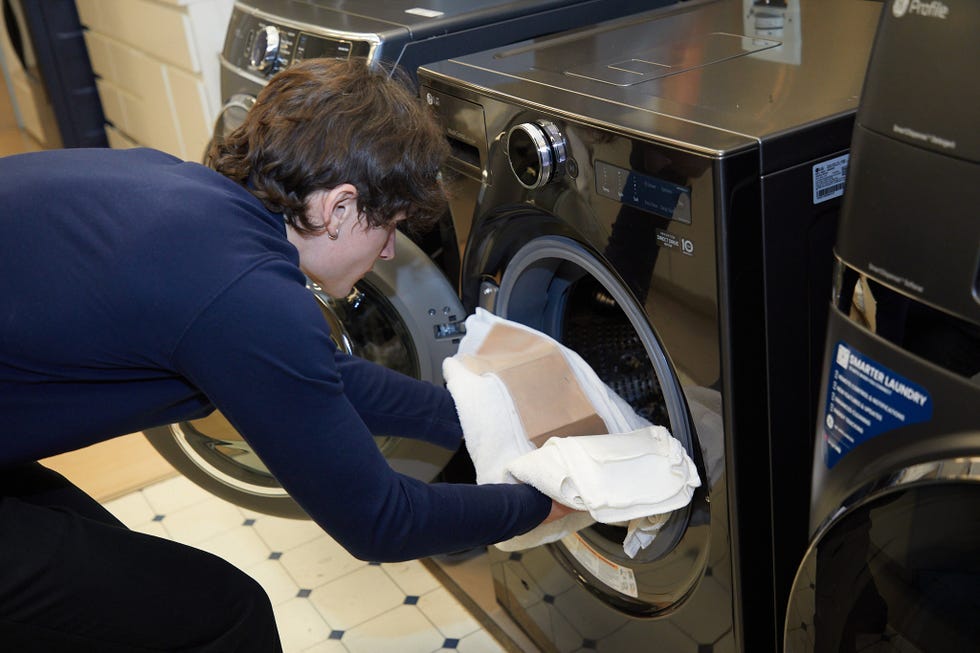 best combo washer and dryer tester putting a stain swatch in a washer
