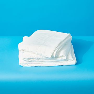 a white folded up cooling comforter from rest on a blue surface