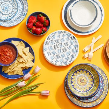 a yellow table with various colored plates and bowls
