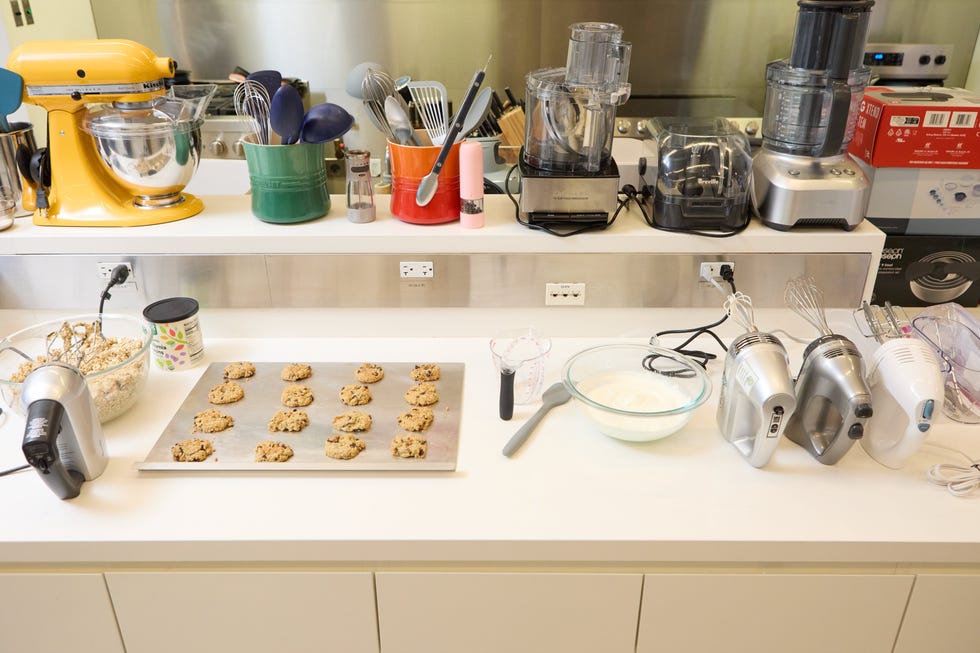 hand mixers, cookies and bowl of whip cream sitting on a counter