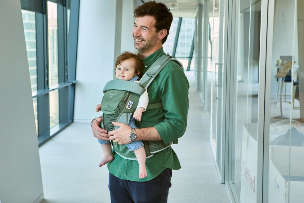 parent carrying a child in a baby carrier