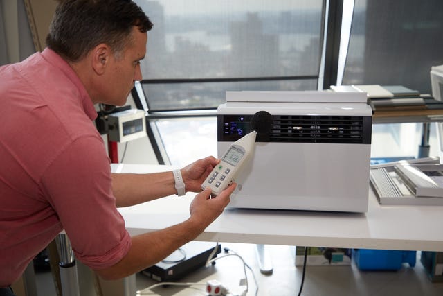 a man using a sound meter on an air conditioner