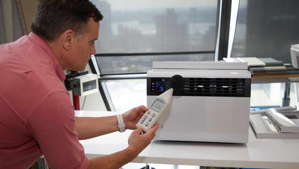 a man using a sound meter on an air conditioner