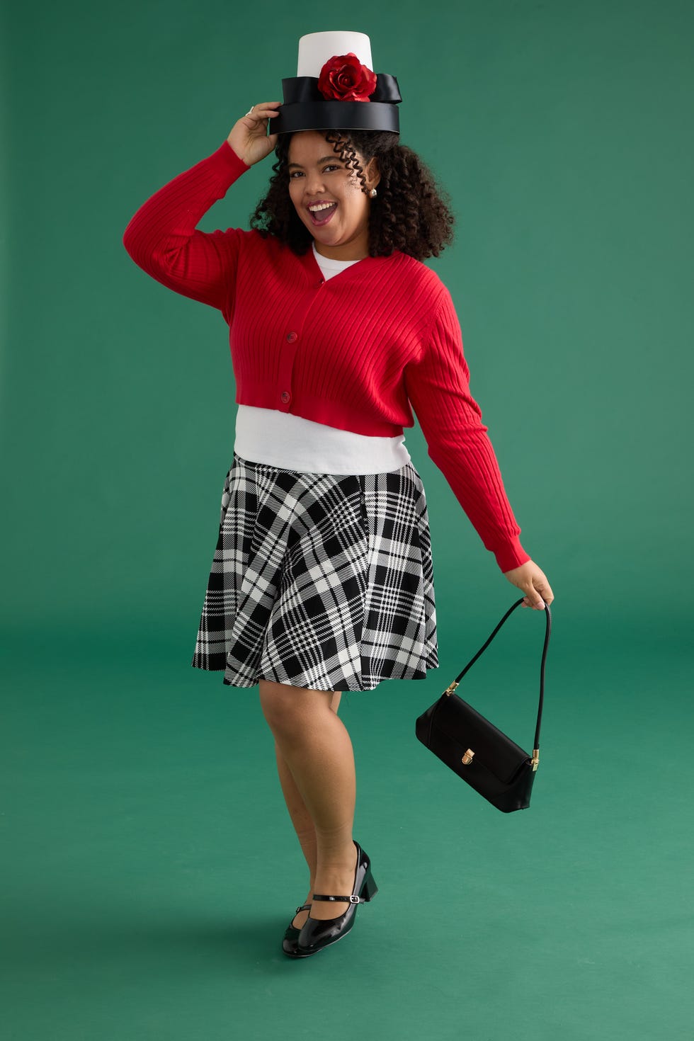 woman wearing a stylish outfit with a unique hat posing against a solid background
