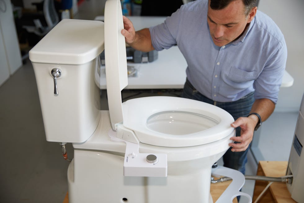 a man examines a toilet during testing