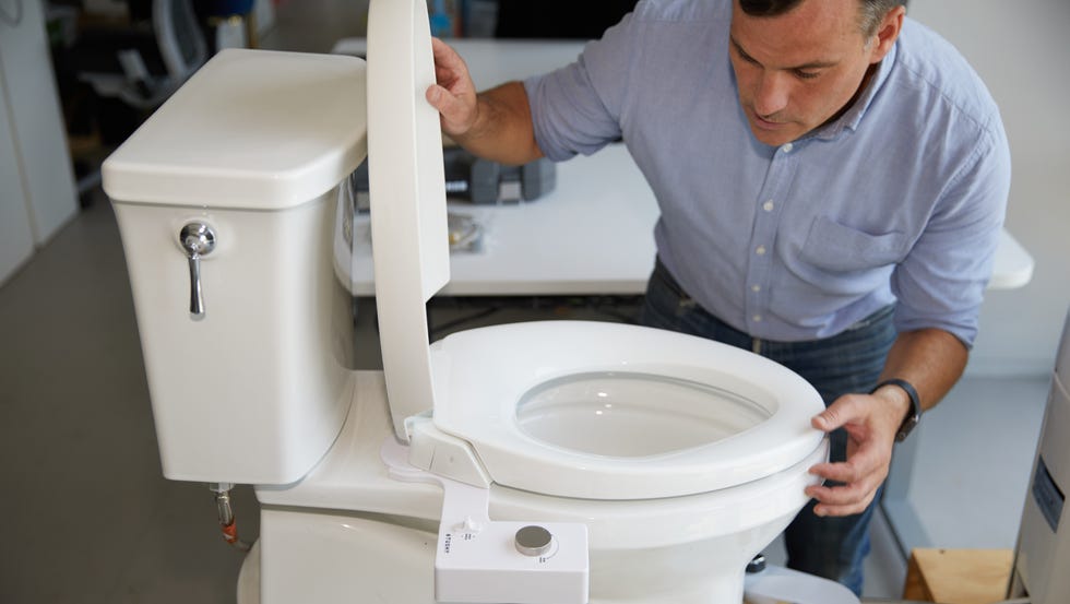 toilet testing a man examines a toilet during testing