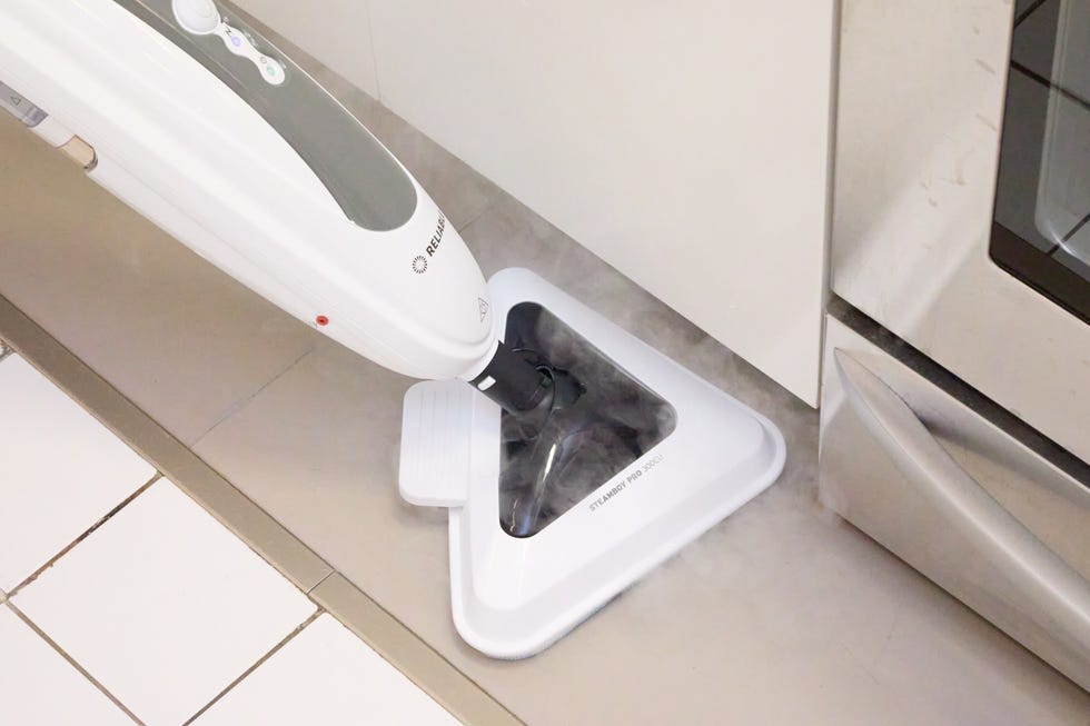 black and white steam mop on a white tile floor