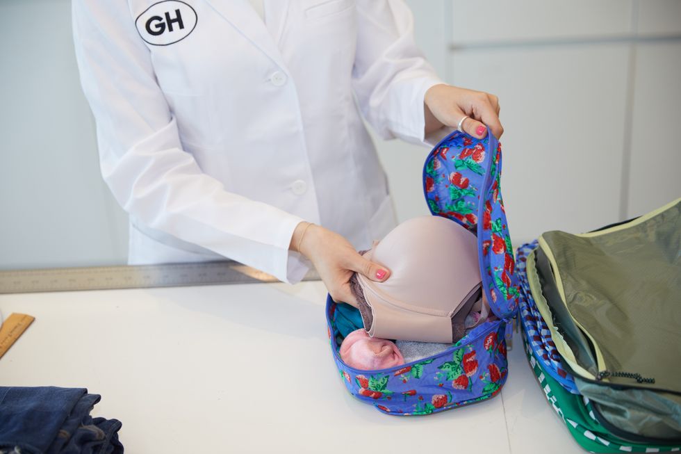 an analyst putting a bra in a baggu packing cube, good housekeeping's best packing cubes
