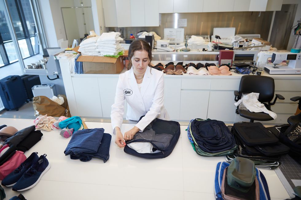 a good housekeeping analyst testing packing cubes with a standard load of clothes in the textiles lab, good housekeeping's best packing cubes
