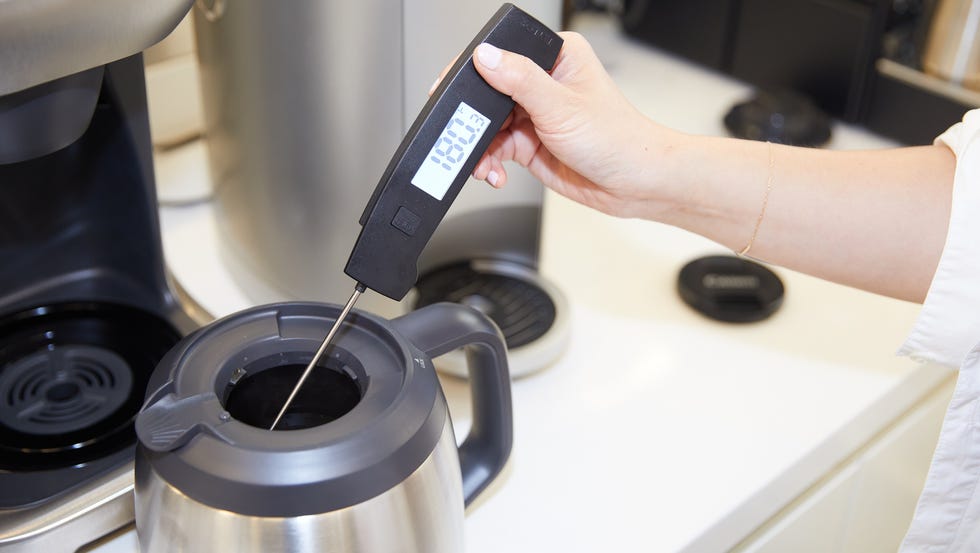 a person using a coffee maker a person using a coffee maker