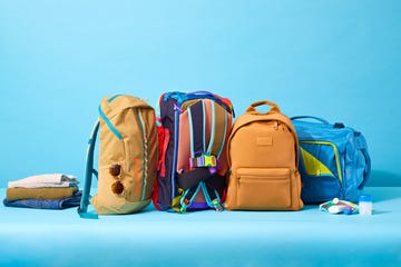 four travel backpacks side by side on a blue background