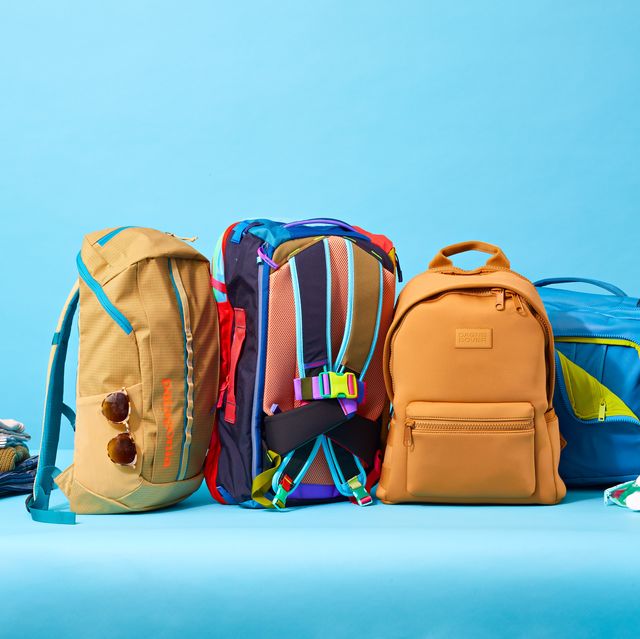 four travel backpacks side by side on a blue background