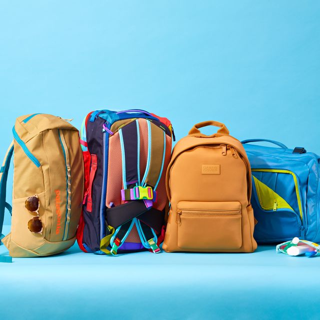 four travel backpacks side by side on a blue background