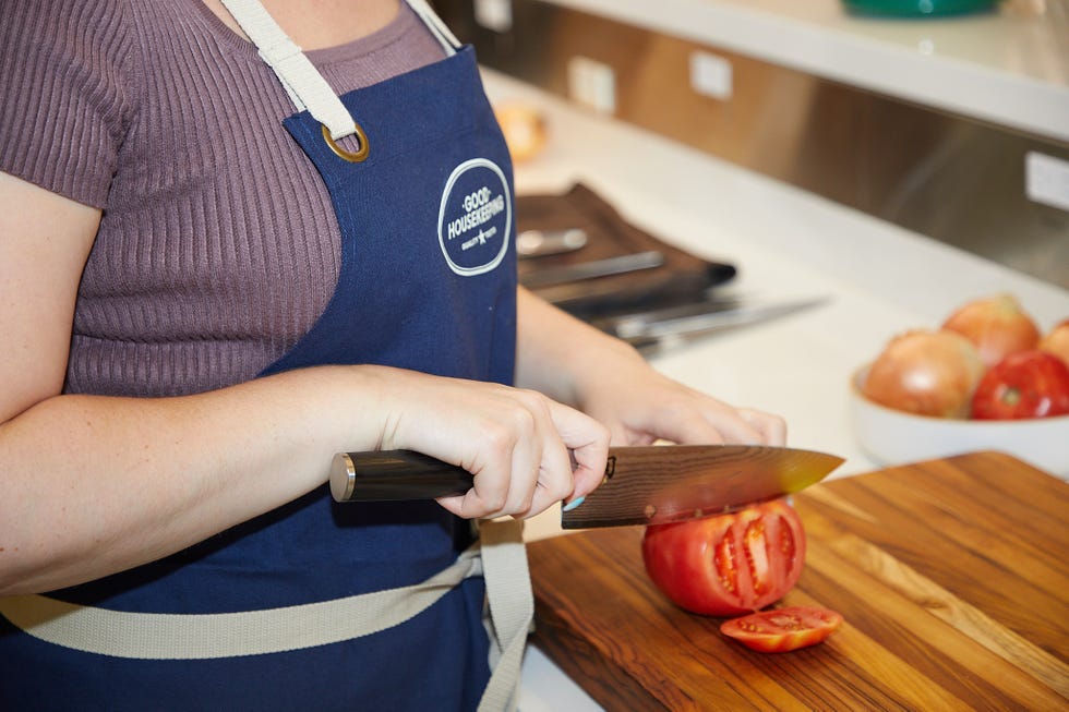 Chopping a tomato on a wooden cutting board