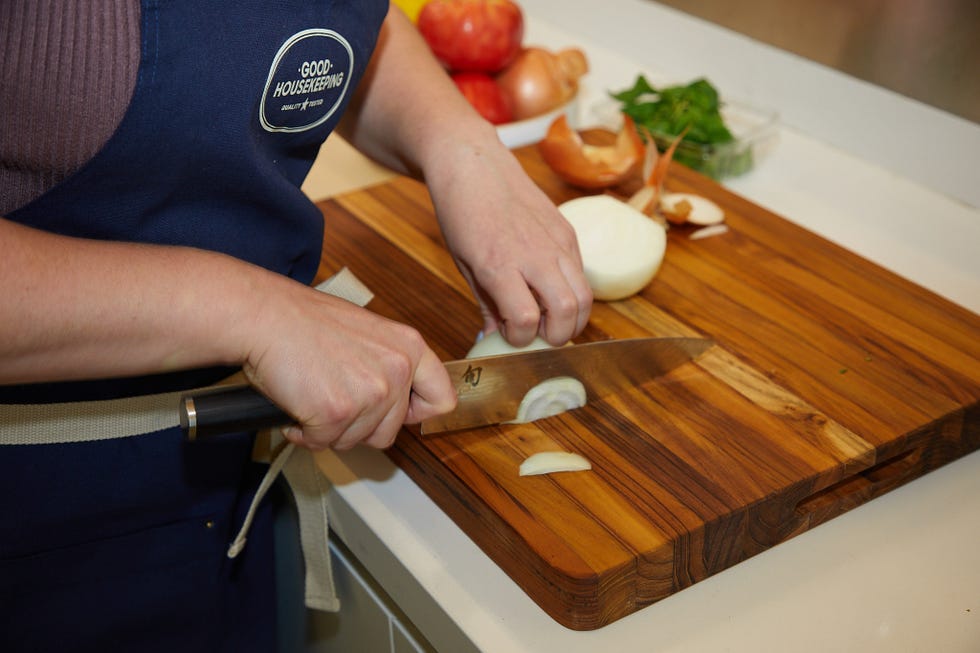 gh analyst chopping an onion on a cutting board