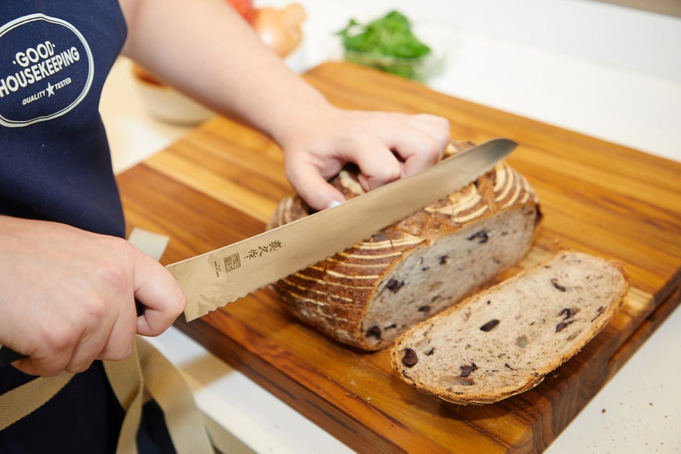 Cutting a loaf of bread on a wooden cutting board