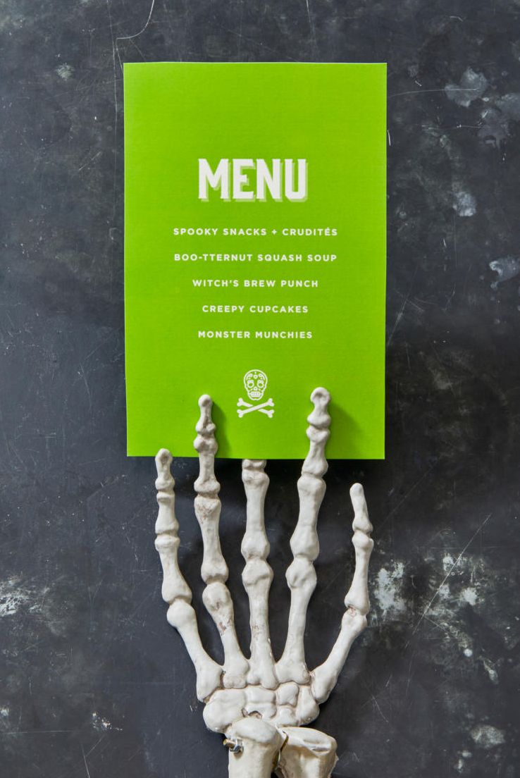 halloween party ideas, skeleton hand holding a green menu