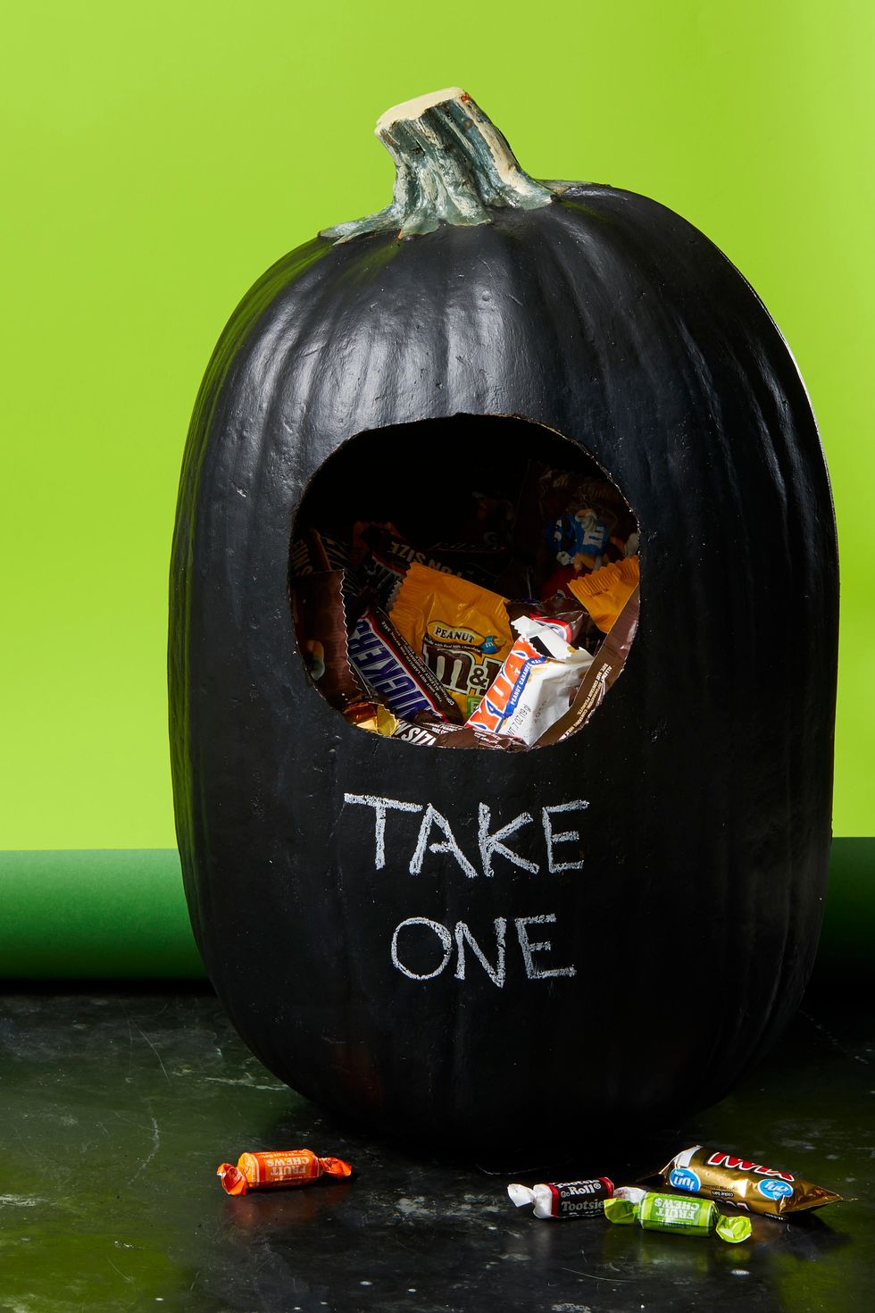 pumpkin carving ideas, black pumpkin with a hole inside filled with candy