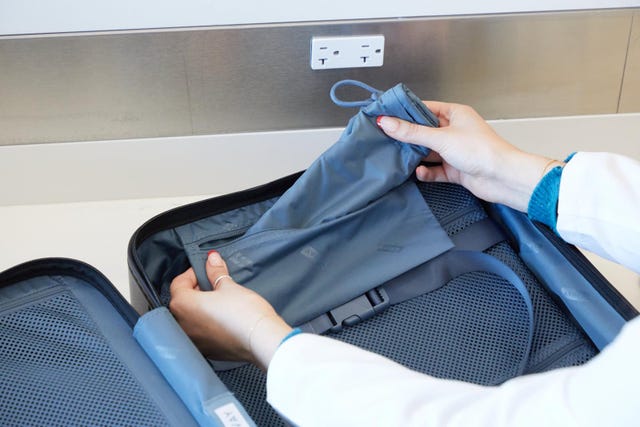 hands inspecting the interior of a suitcase