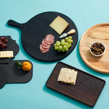 best charcuterie boards multiple charcuterie boards on a blue background with food such as crackers, grapes, salami, olives and cheese