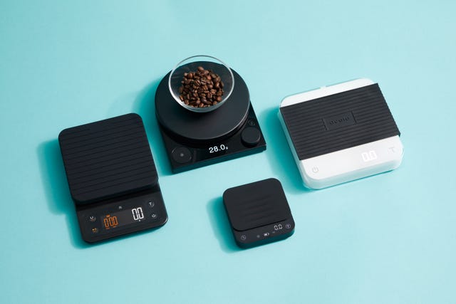 four coffee scales on a blue background with a bowl of coffee on one scale
